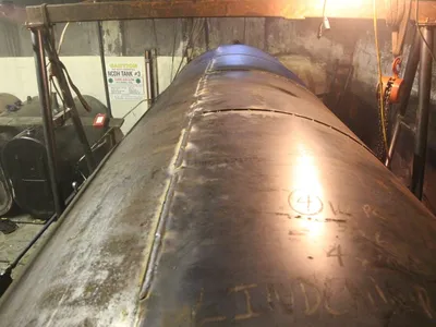 Welded repair seam on a steel fuel-oil tank in a basement boiler room