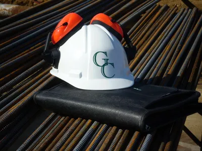 G.C. Environmental hard hat with ear protection resting on bundled rebar