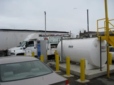 White aboveground fuel tank and dispenser beside a G.C. Environmental truck