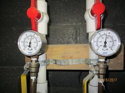 Pair of vacuum gauges and red ball valves on a PVC sampling manifold