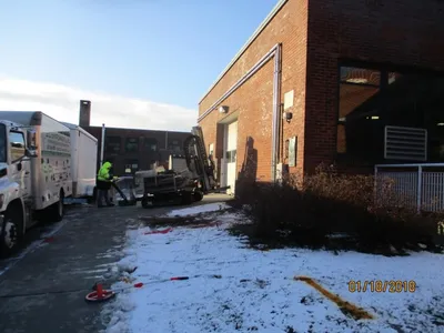 G.C. Environmental truck and tracked rig staged by a brick building in winter