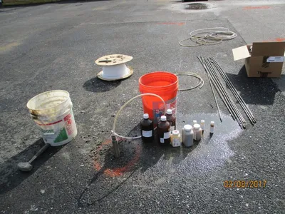 Groundwater sampling gear laid out on pavement with labeled sample bottles and tubing
