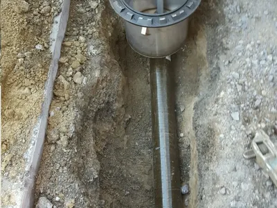Stainless spill-containment sump installed over fuel piping in an excavated trench