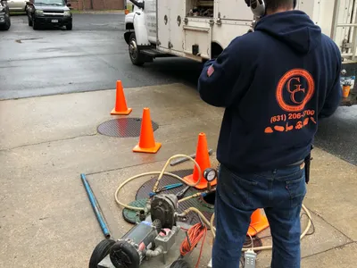 GCE worker operating a wheeled test pump beside the company truck