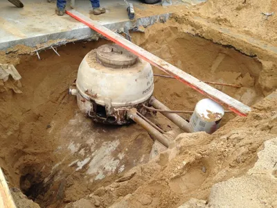 Exposed tank sump and piping during a repair in an open excavation
