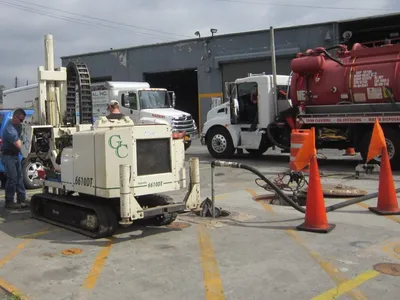 G.C. Environmental Geoprobe rig and red vacuum truck at a tank-cleaning site