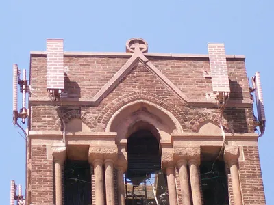 Cellular antennas mounted atop the arched brick belfry of an old tower