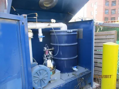 Interior of the remediation enclosure showing a blower, knockout vessel, and drum