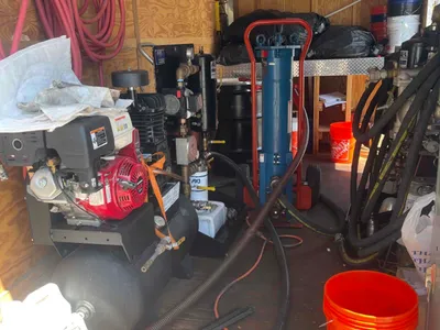 Trailer interior with an engine-driven pump, blue filter vessel, and coiled hoses