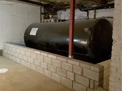 Basement fuel oil tank seated on a concrete-block secondary containment wall
