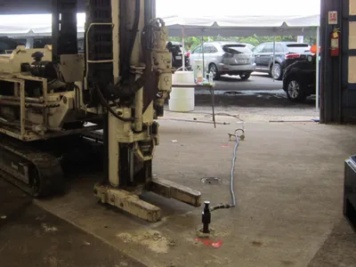 GCE track-mounted drill rig parked in a garage bay over a floor well point