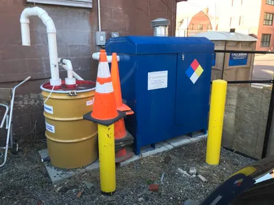 GCE soil vapor extraction unit with blue cabinet, PVC piping, and carbon drum outdoors